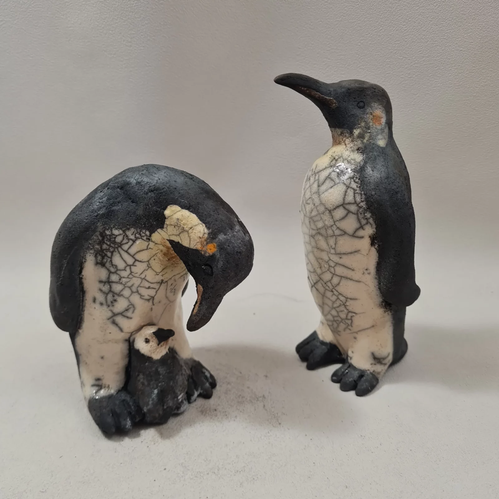 Famille de manchots empereurs en céramique raku parents et petit sculptures artisanales