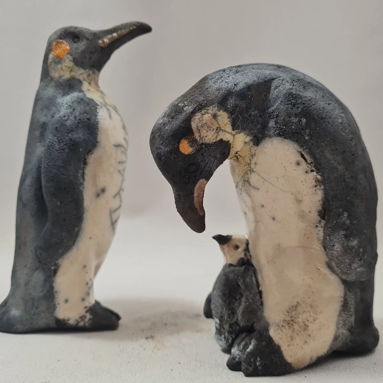 Famille de manchots empereurs en céramique raku parents et petit sculptures artisanales