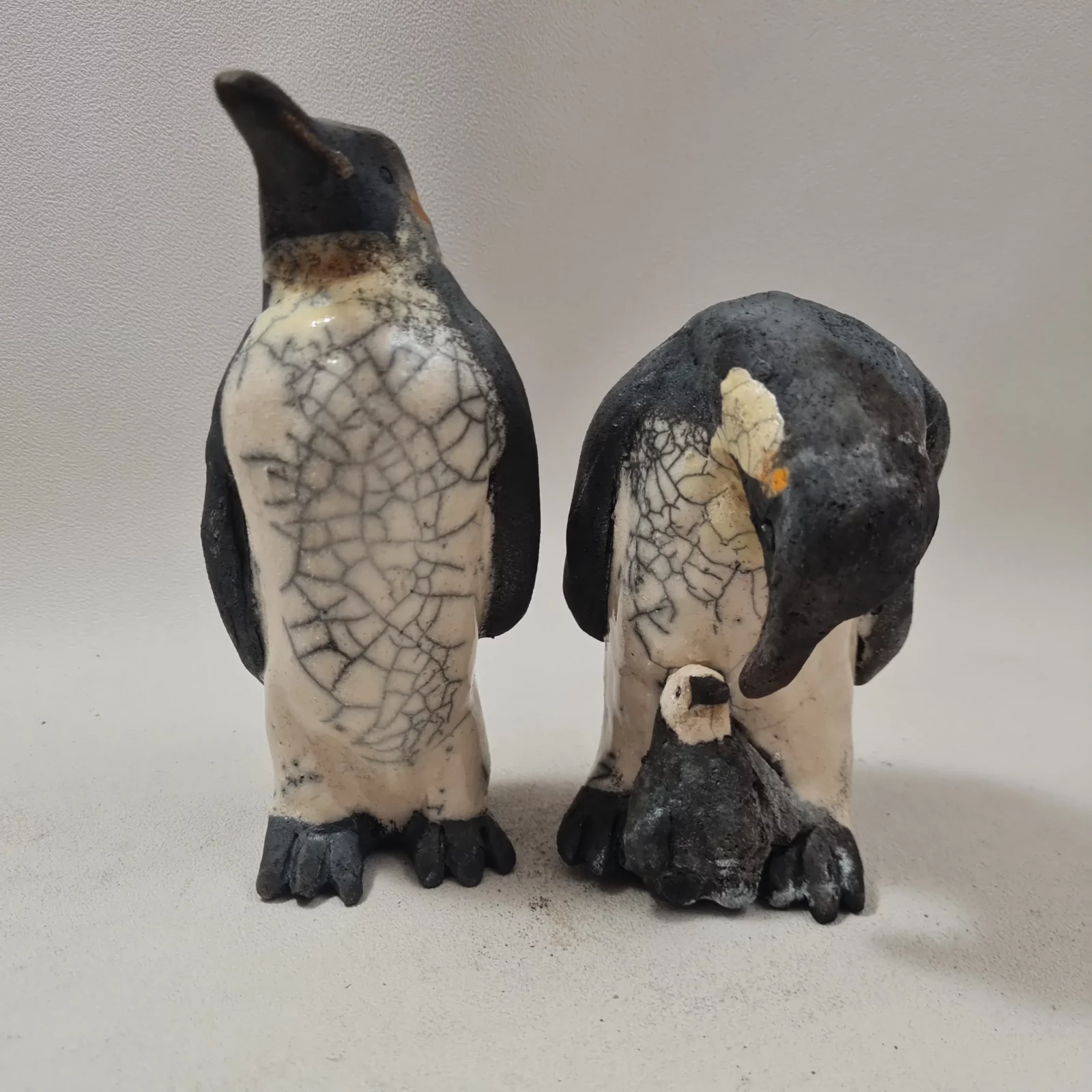 Famille de manchots empereurs en céramique raku parents et petit sculptures artisanales